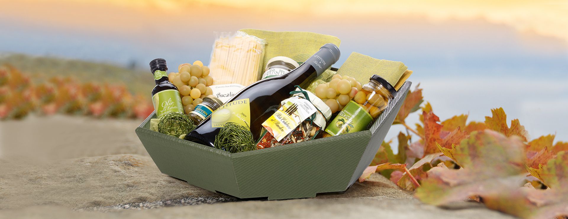 Zeshoekige geschenkmand van open golfkarton en schuine voorkant met witte wijn en olijven.